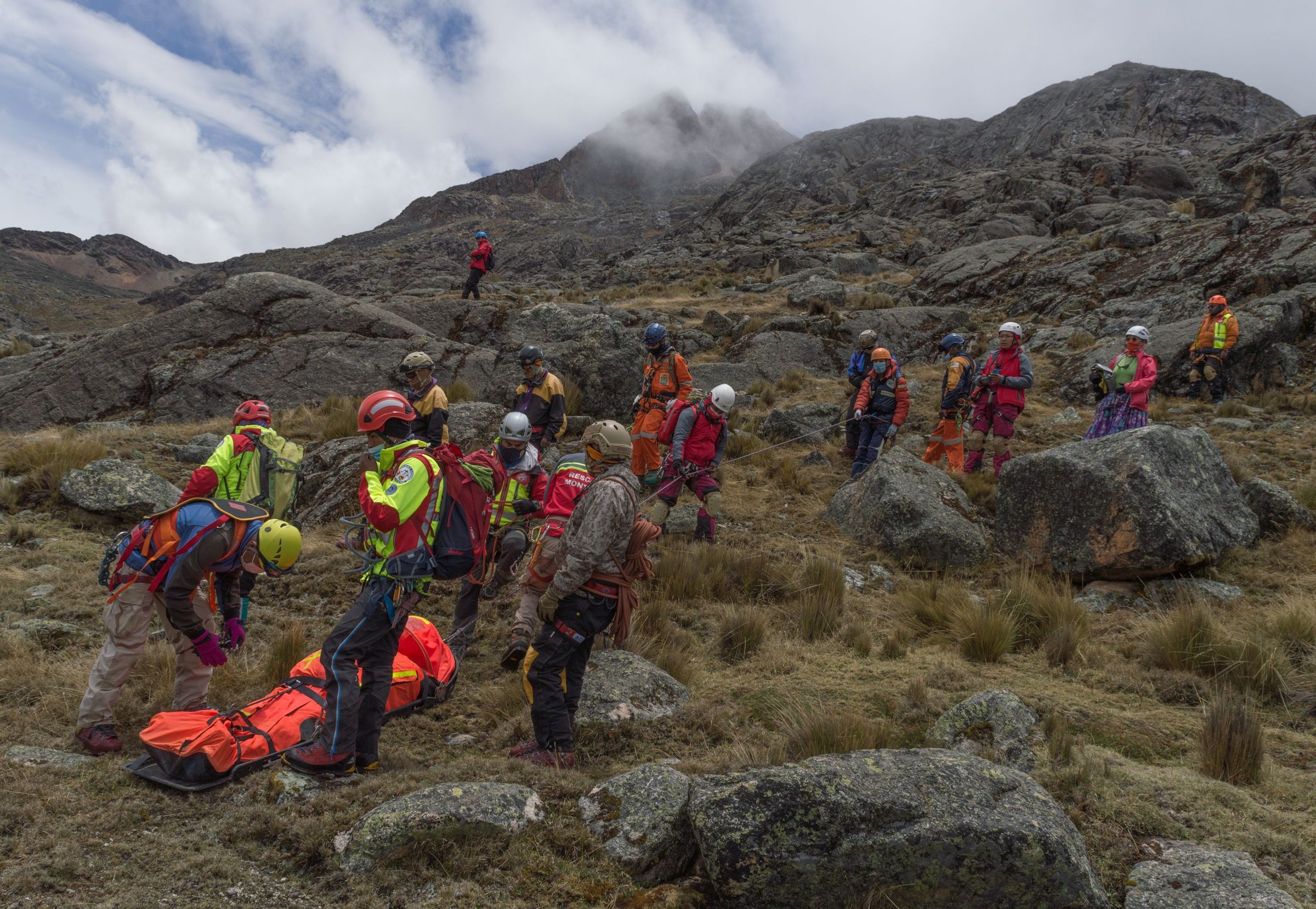 Equipo de rescate trabajando en terreno cordillerano con camilla de rescate y cuerdas